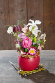 Spring flowers in red wax vase