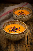 Orientalische Karotten-Ingwer-Kokos-Suppe mit schwarzem Sesam und Granatapfelkernen