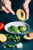 Guacamole mit Avocado, Tomate, Zwiebel, Zitrone und Koriandergrün vorbereiten