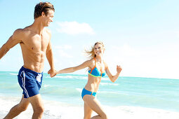 Junges Paar beim Laufen am Strand