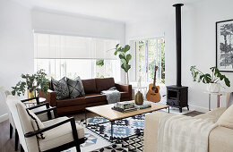 Leather and upholstered furniture around coffee table in living room with log burner