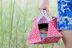 Woman carrying cake in springform pan in handmade oilcloth cake bag