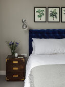 Doppelbett mit Bettkopfteil, Wandleuchte und Nachtkästchen im Schlafzimmer
