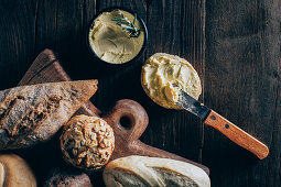 Different types of bread and butter on wooden background