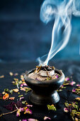 A smoking incense blend in an incense bowl