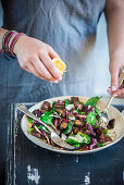 Squeezing lemon over a chicken liver salad