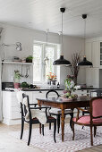 Antique dining table and chairs in white kitchen-dining room