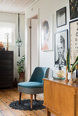 Retro sideboard and easy chair below collection of pictures