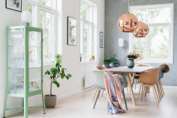 Table, shell chairs and glass cabinet in bright dining room