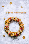 Christmas wreath of gingerbread dough in the shape of stars and snowflakes, barberry twigs, tied with a silver ribbon