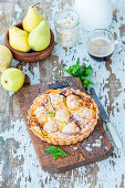 Birnenkuchen mit Mandelblättchen auf Holzbrett