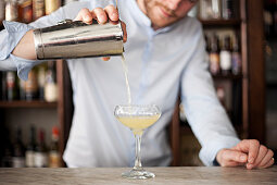A barman pouring a cocktail