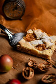 A piece of apple pie with cinnamon and nuts on a cake slice