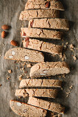 Homemade cantuccini with almonds on a baking sheet (top view)