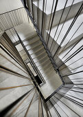 Concrete staircase with metal banisters in stairwell (view from top)