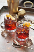 Two old fashioned cocktails in cut glasses with mixing equiptment