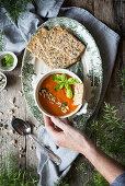 Hand holding a bowl with Red Pepper cream