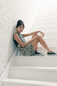 Junge asiatische Frau in schwarz-weiß gemustertem Minikleid