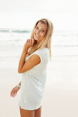 Blonde Frau in weißem Longshirt am Strand
