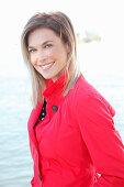 A blonde woman wearing a red trench coat