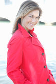 A blonde woman wearing a red trench coat