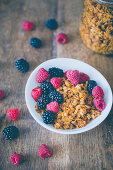 Granola with raspberries and blackberries, on a wooden surface
