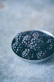 Freshly picked blackberries in a small metal bowl