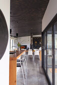 Bar stools on wooden breakfast bar in front of patio doors