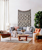 Gray upholstered sofa with pillows, coffee table, armchair and chair as storage furniture