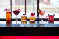 Six different cocktails and drinks on a bar counter