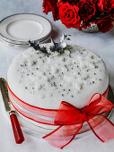 Christmas cake decorated with white fondant and red ribbon