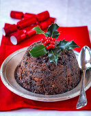 Christmas Pudding with sprig of Holly and Christmas crackers