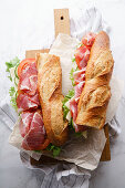 Fresh baguette sandwich bahn-mi styled, with ham, sliced cheese, tomatoes and fresh lettuce