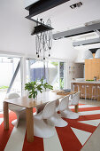 Designer chairs at the dining table in front of the open kitchen