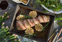 A pork fillet wrapped in bacon with roasted garlic and rosemary