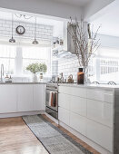 Open kitchen with white glossy fronts and wooden floor