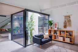 Leather sofa and shelf in front of the glass wall to the light well