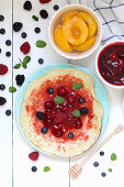 Pancakes with berries and peaches (top view)