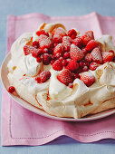 Strawberry and redcurrant pavlova with whipped cream and meringue base