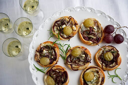 Mini pizzas with chevre, balsamic onions and grapes