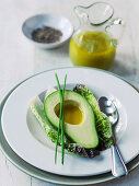 Avocado with vinaigrette dressing and long chive garnish