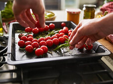 Tomatoes being arranged on a baking tray