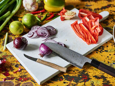 Red onions and red pepper being sliced