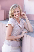 A blonde woman wearing a light blouse