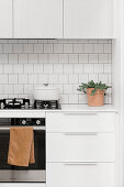 Gas stove in a simple, white kitchen