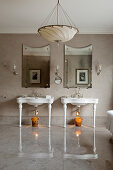 Zwei Standwaschbecken und Wandspiegel im Badezimmer mit grauem Marmorboden, Lampenschirm aus Seide