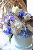 Summery flower arrangement of driftwood and blue and white flowers
