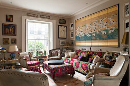 Eklektisches Wohnzimmer mit verschiedenen Kunstwerken, cremefarbenen Ledersesseln, japanisches Wandpaneel mit Vögeln über Sofa