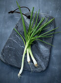 Spring onions on a grey marbled board