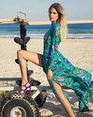 A young woman wearing a colourful summer dress and high heels